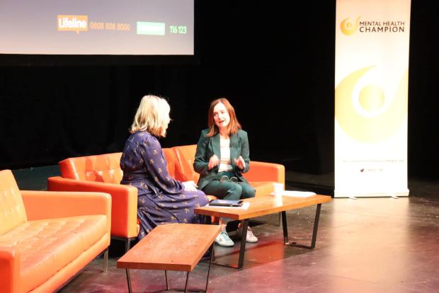 MHC and presenter Tara Mills talking on stage